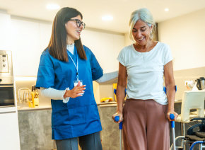aide smiling while taking care of the senior woman