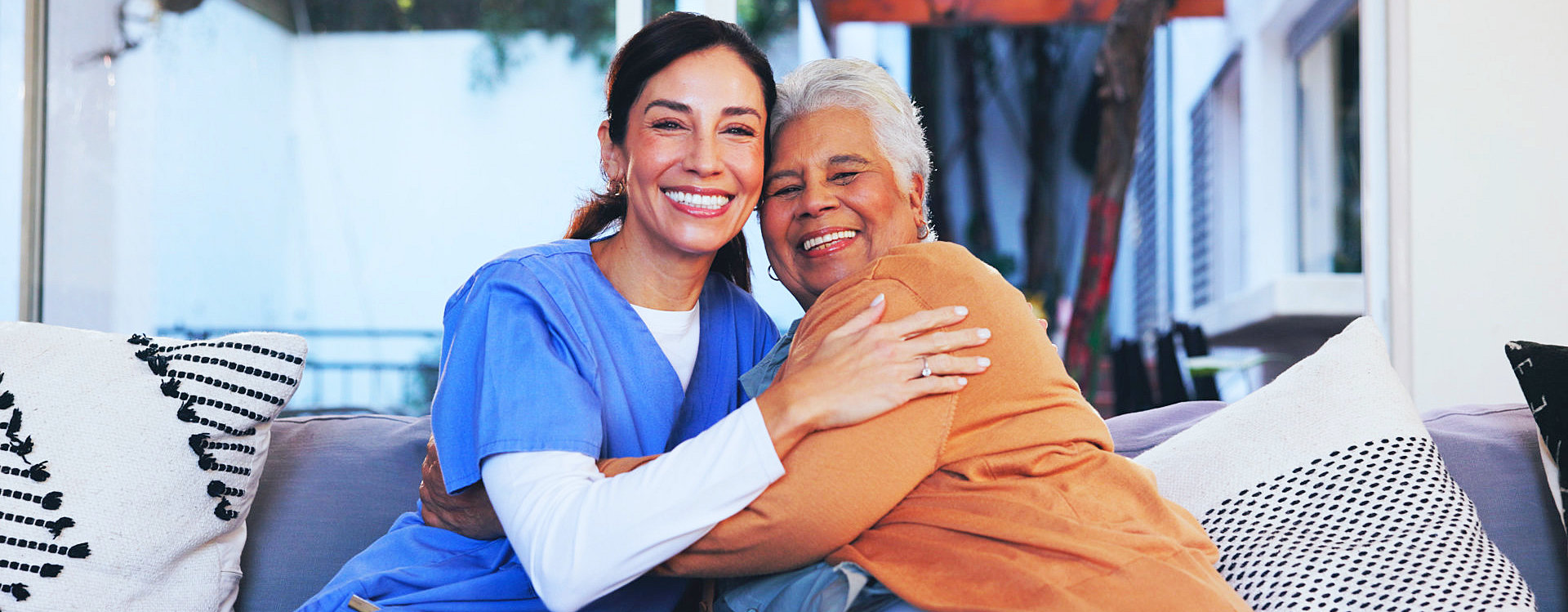aide and senior woman smiling together