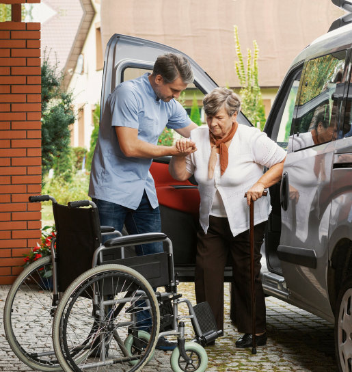 man assisting the senior woman to walk