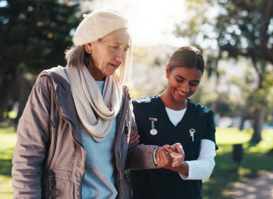 aide smiling while taking care of the senior woman