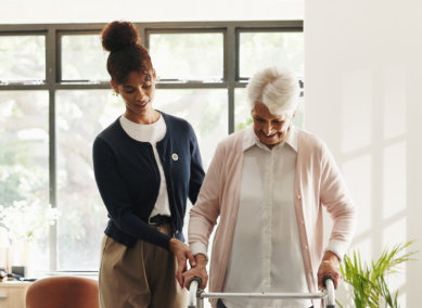 aide assisting the senior woman to walk