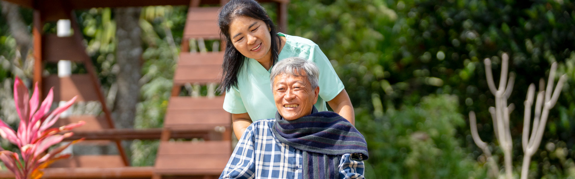 aide and senior man smiling outside