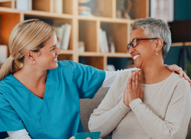 aide and senior woman smiling at each other
