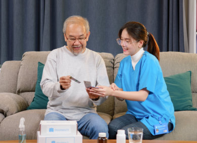 aide assisting the senior man on his medication