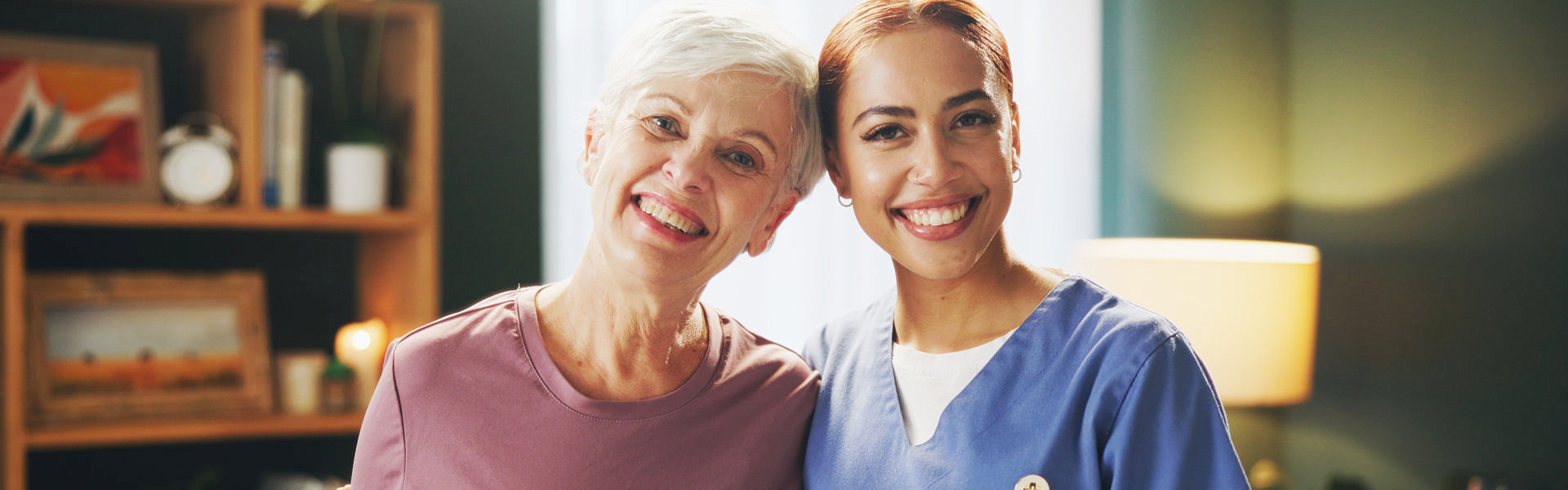 aide and senior woman smiling together