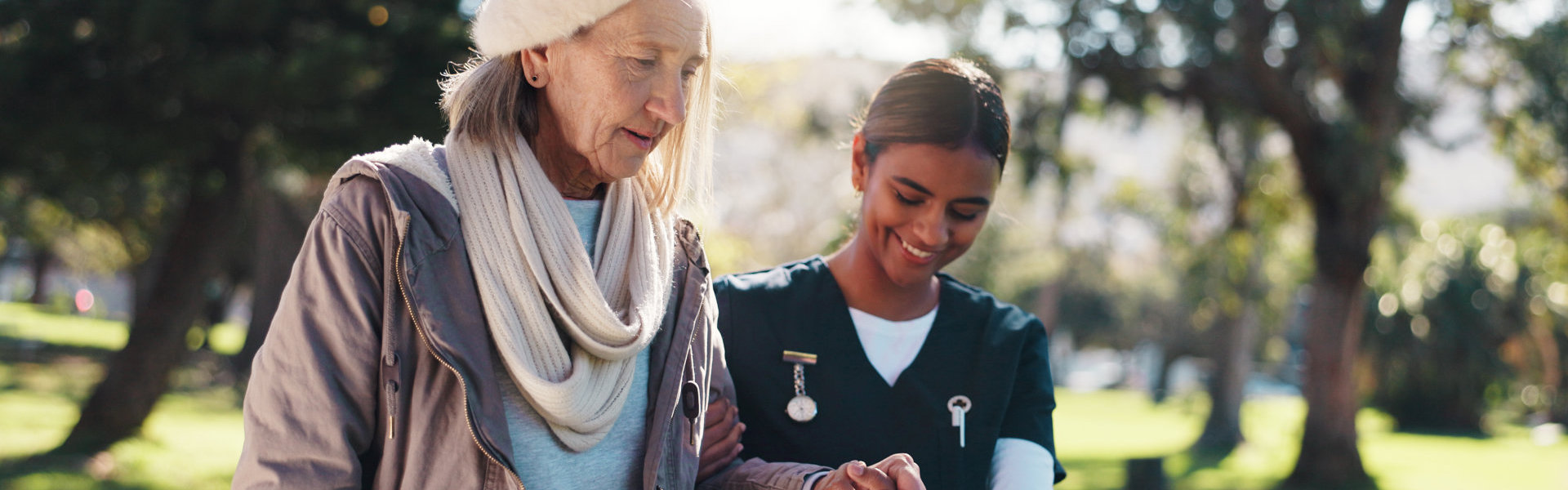 aide assisting the senior woman to walk