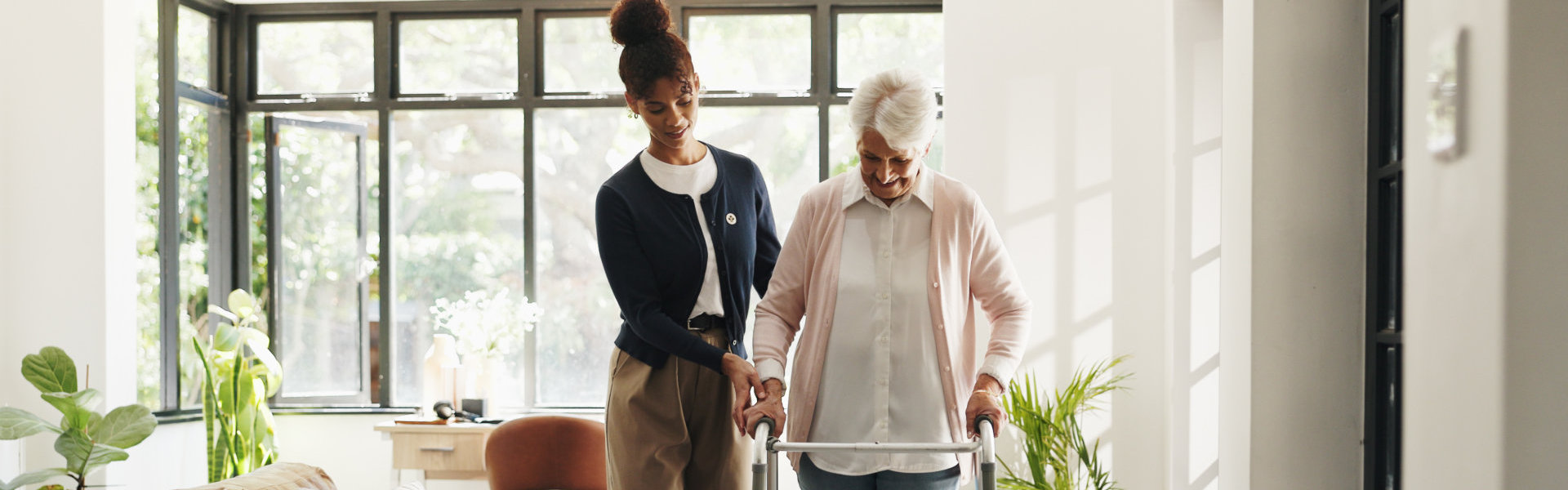 aide assisting the senior woman to walk